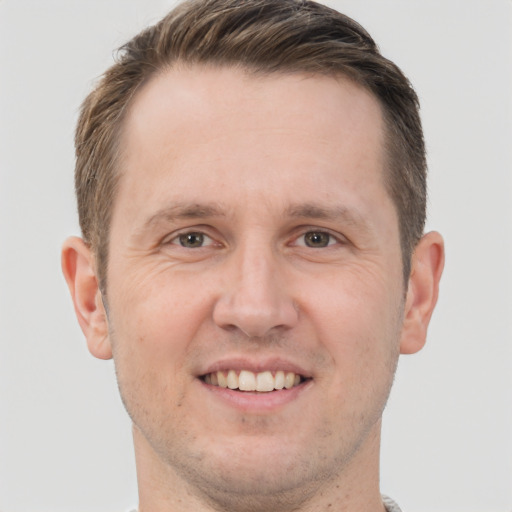 Joyful white adult male with short  brown hair and grey eyes