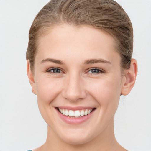 Joyful white young-adult female with short  brown hair and grey eyes