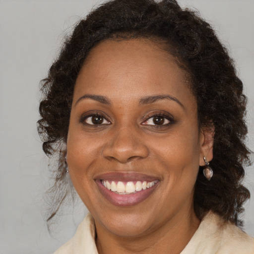 Joyful black young-adult female with medium  brown hair and brown eyes