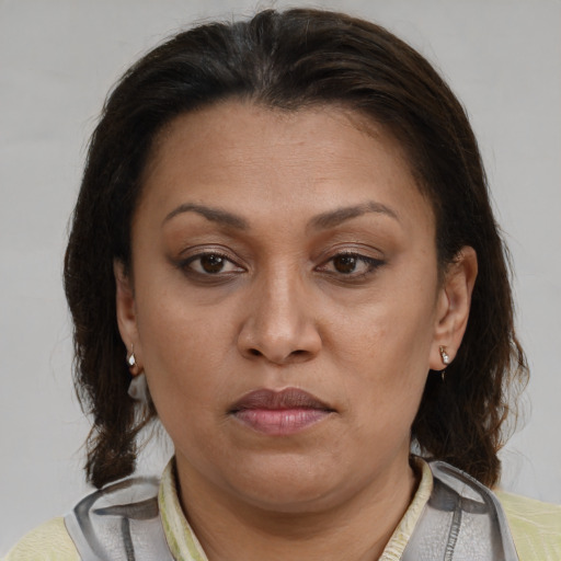 Joyful latino adult female with medium  brown hair and brown eyes