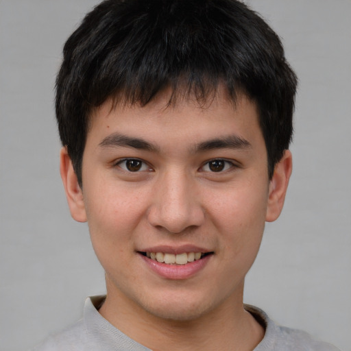 Joyful asian young-adult male with short  brown hair and brown eyes