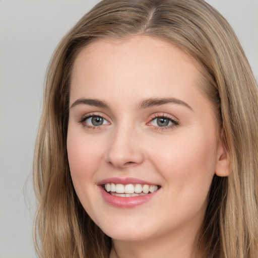 Joyful white young-adult female with long  brown hair and grey eyes