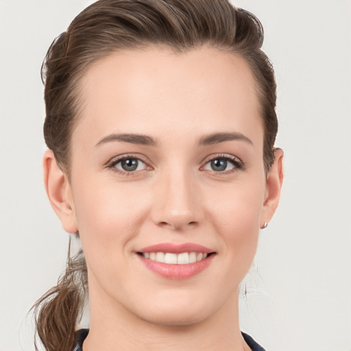 Joyful white young-adult female with medium  brown hair and grey eyes