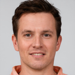 Joyful white young-adult male with short  brown hair and grey eyes