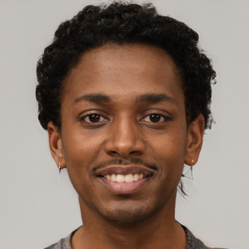 Joyful black young-adult male with short  black hair and brown eyes