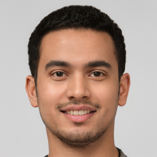 Joyful latino young-adult male with short  brown hair and brown eyes