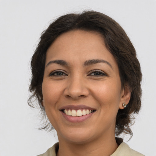Joyful latino young-adult female with medium  brown hair and brown eyes