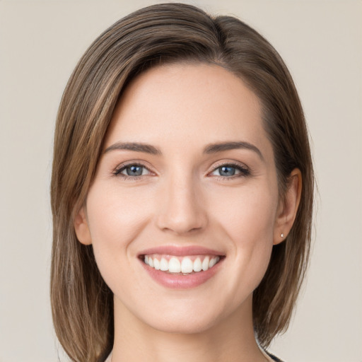 Joyful white young-adult female with medium  brown hair and green eyes