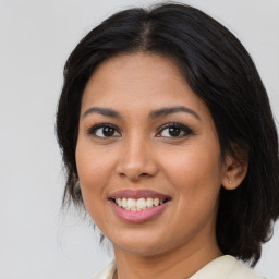 Joyful latino young-adult female with medium  brown hair and brown eyes