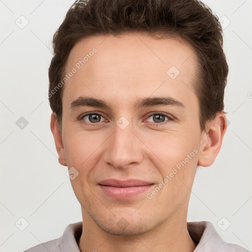 Joyful white young-adult male with short  brown hair and grey eyes