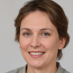 Joyful white adult female with medium  brown hair and grey eyes