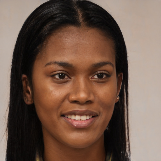 Joyful black young-adult female with long  brown hair and brown eyes