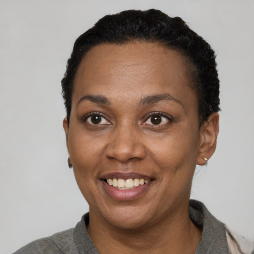 Joyful black adult female with short  black hair and brown eyes