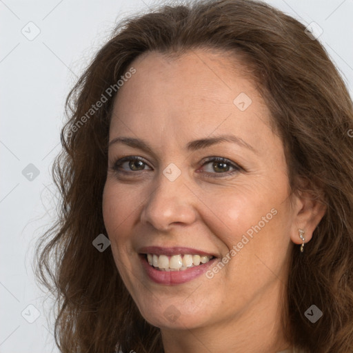 Joyful white adult female with long  brown hair and brown eyes