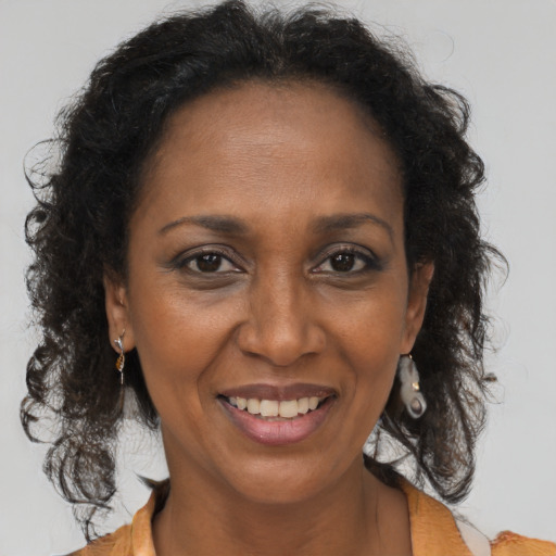 Joyful black adult female with long  brown hair and brown eyes