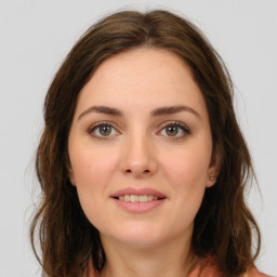 Joyful white young-adult female with long  brown hair and green eyes