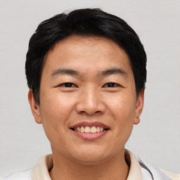 Joyful asian young-adult male with short  black hair and brown eyes