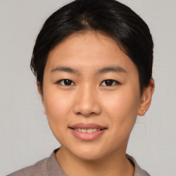 Joyful asian young-adult female with short  brown hair and brown eyes