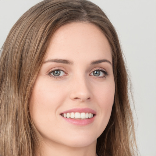 Joyful white young-adult female with long  brown hair and green eyes