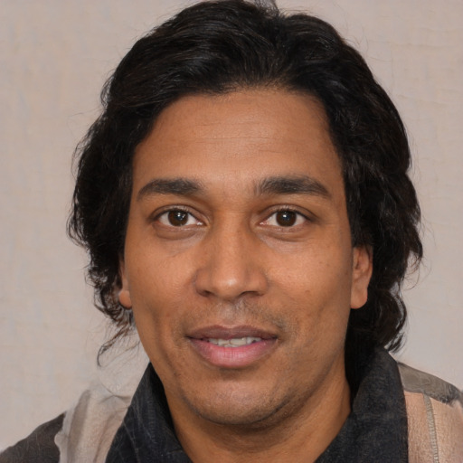 Joyful latino adult male with medium  black hair and brown eyes
