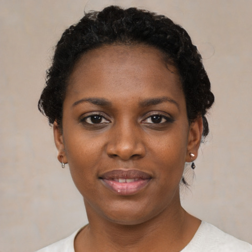 Joyful black young-adult female with short  black hair and brown eyes