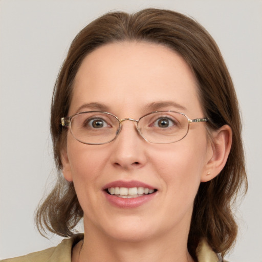 Joyful white adult female with medium  brown hair and blue eyes