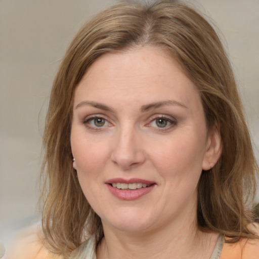 Joyful white young-adult female with medium  brown hair and green eyes