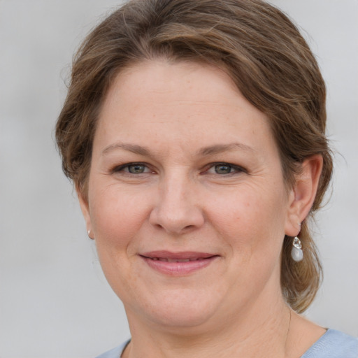 Joyful white adult female with medium  brown hair and grey eyes