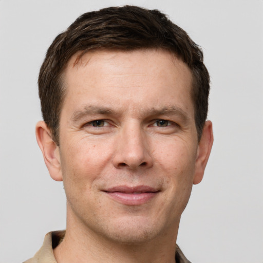 Joyful white adult male with short  brown hair and grey eyes