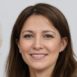 Joyful white adult female with long  brown hair and brown eyes