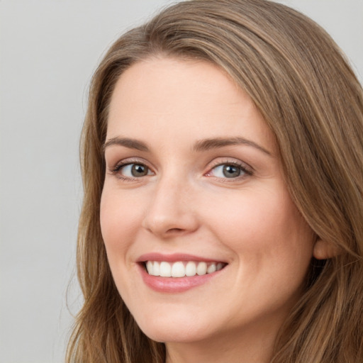 Joyful white young-adult female with long  brown hair and green eyes