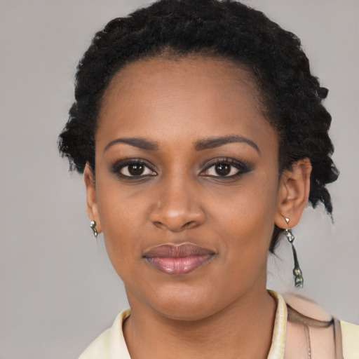 Joyful black young-adult female with short  black hair and brown eyes