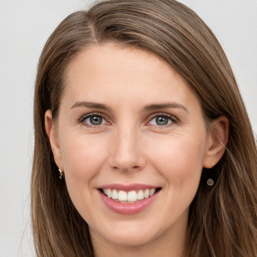 Joyful white young-adult female with long  brown hair and grey eyes