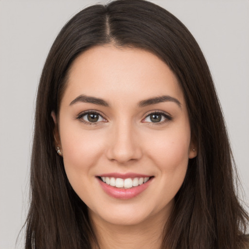 Joyful white young-adult female with long  brown hair and brown eyes