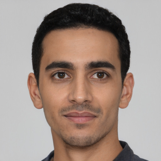 Joyful latino young-adult male with short  black hair and brown eyes