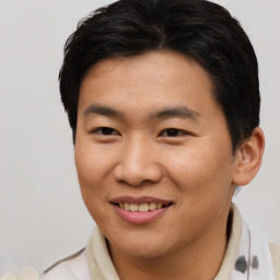 Joyful asian young-adult male with short  brown hair and brown eyes