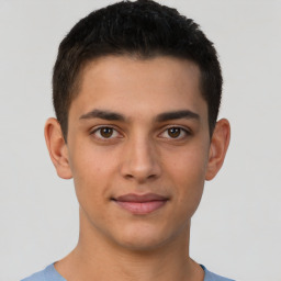 Joyful latino young-adult male with short  brown hair and brown eyes