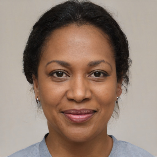 Joyful black adult female with medium  brown hair and brown eyes