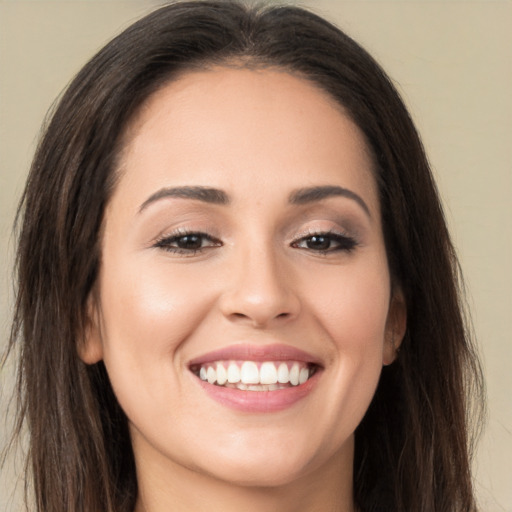 Joyful white young-adult female with long  brown hair and brown eyes