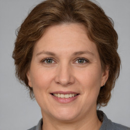 Joyful white adult female with medium  brown hair and grey eyes