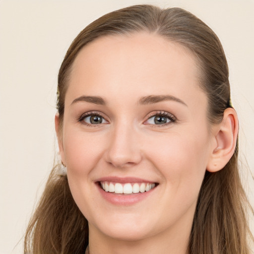 Joyful white young-adult female with long  brown hair and blue eyes