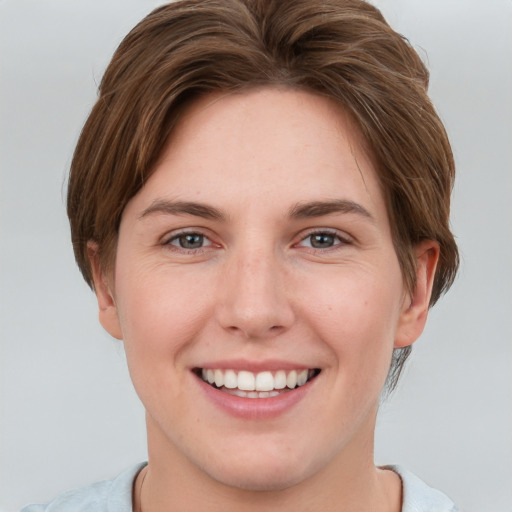 Joyful white young-adult female with short  brown hair and grey eyes