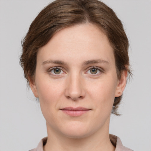 Joyful white young-adult female with medium  brown hair and grey eyes