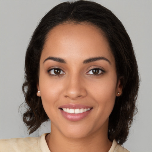 Joyful latino young-adult female with medium  brown hair and brown eyes