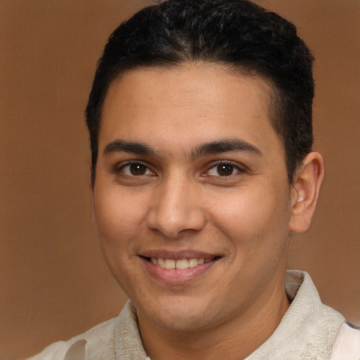 Joyful latino young-adult male with short  brown hair and brown eyes