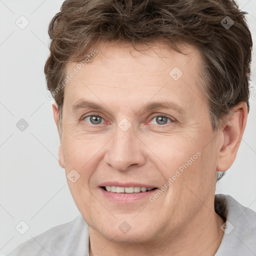 Joyful white adult male with short  brown hair and grey eyes