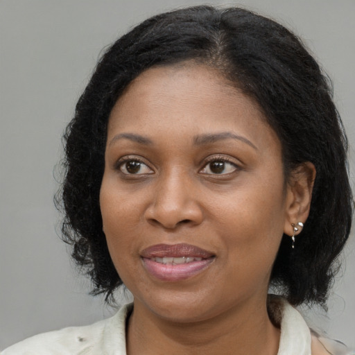 Joyful black adult female with medium  brown hair and brown eyes