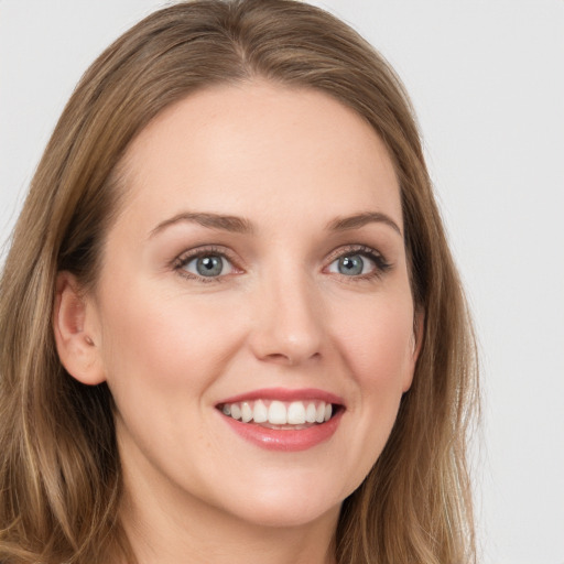 Joyful white young-adult female with long  brown hair and green eyes