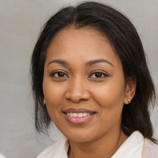 Joyful latino adult female with medium  brown hair and brown eyes