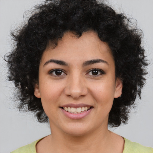 Joyful black young-adult female with medium  brown hair and brown eyes